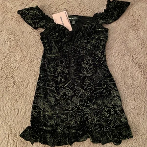 Klänning New Girl Order - En otroligt fin klänning med guldglittriga stjärntecken över hela sig 🥺 !! Storleken är UK10, så en 38 i eu-storlek. OBS - den är helt oanvänd. 