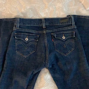 Levis Tilted Flare | strl 36/38 - (KÖP DIREKT FÖR 250 kr) Lågmidjade bootcut jeans från Levis med så coola fickor men som tyvärr är för små för mig. Därför har jag inte egna bilder med dem på utan tog några från originalsäljaren. Borde passa en 36/38. Midjemåttet: 80 cm | Innerbenet: 78 cm. Hon på bilden har storlek 36 och är 167 cm. Tveka inte att kontakta mig vid frågor/ intresse! 