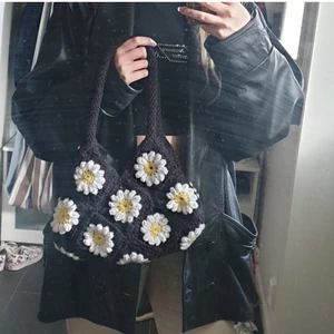 Puff Daisy crochet bag - Handvirkad väska med blommönster. Finns en i svart vit och en i lila vit. Mönstret är på båda sidorna av väskorna och väskan är linjerat med ett tunt linne tyg.
