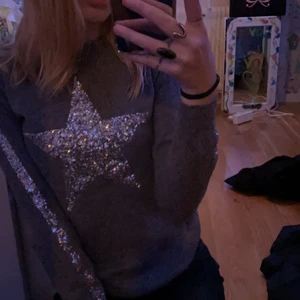 Tröja - Säljer denna jätte fina trendiga tröjan som tyvärr inte kommer till användning! Den har en stjärna på framsidan och en silvrig rand på båda ärmarna! Den är lite tajt i ärmarna på mig som är en S och den är ganska lång men det är enkelt att vika upp som jag gjorde på första bilden