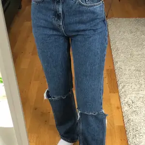 Ett par blåa jeans från Weekday i modellen voyage. Hål vid knäna och slits på insida (se sista bilden)🤩