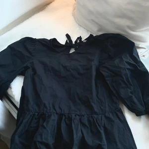 Blus - Svart blus med puffärmar och knytning i ryggen från H&M. Andänd ett antal gånger men är i bra skick!