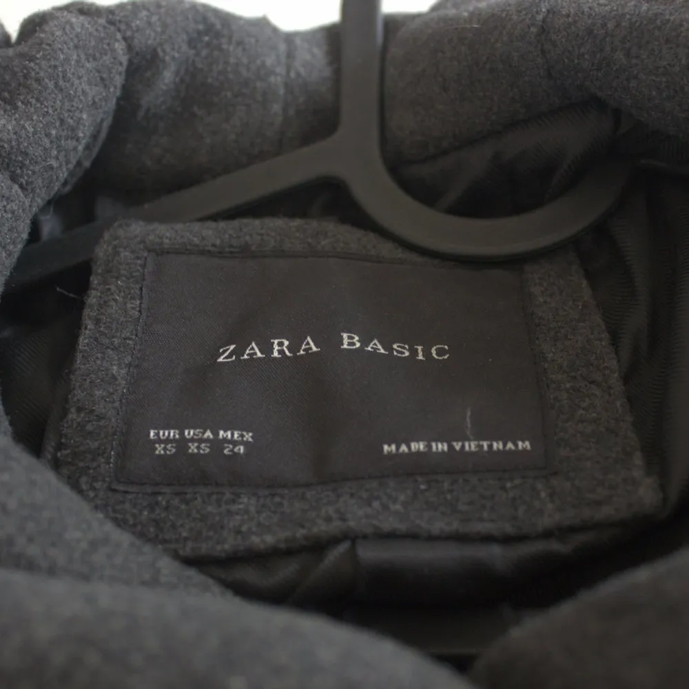 Nice and warm medium length (approx 90cm long) coat in gray color. The coat has a big and warm hood. The size is XS and the brand is Zara. Used, but in a good state.. Jackor.