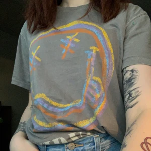 Nirvana t-shirt - Säljer en grå t-shirt med tryck både fram och bak med motiv nirvana. En relativt stor tröja, snygg som oversized och sitter väldigt bekvämt. Jag är 173 och brukar ha storlek S