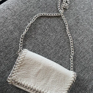 Tiamo väska - s - Väska från TIAMO, den minsta modellen. I nyskick, då den aldrig är använd utan bara legat i påsen den kom i.. går att ta bort bandet så det blir som en clutch. Väskan stängs med dragkedja och knapp. Ryms det nödvändigaste!