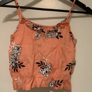Blommig Orange färgad Top  - En orange färgad blommig top med lite volanger i storleken XS från Sinsay. Testad engång och därefter aldrig använt för den var för liten. Den var tänkt att användas som Crop Top. ✨