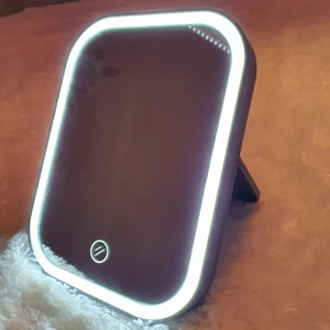 Sminkspegel - Liten sminkspegel med lampor, drivs på batterier vilket ej medföljer. Inga problem eller defekter finns.