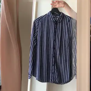 Button up striped navy white shirt, it’s size 42, it can be worn by those who wear a medium size,  it is equivalent to size M, also those who wear an even smaller size, a baggy look would be cool. 