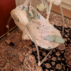 Babygunga  - Innegunga från Fillikid med timer-funktion (10, 20 och 30 min) och tre olika gunghastigheter. Gungan både lugnar och underhåller barnet på samma gång. Babygungan har åtta olika melodier och en båge med aktivitetsleksaker, bågen är avtagbar och går att justera i höjd. Med fempunktsbälte så att barnet sitter säkert i gungan. Drivs av den medföljande adaptern (230 V) eller 4 C-LR14 batterier (ingår inte).  Avtagbar och justerbar lekbåge Avtagbar kudde 5-punkts bälte Timer-funktion Tre olika gunghastigheter Med musik Laddare ingår Mått: L65 x B60 x H63 cm
