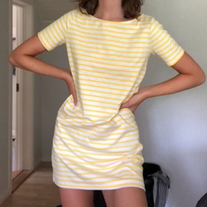 Gul/vit randig klänning - Fin t-shirt klänning som är för kort och som inte kommer till användning! Lite nopprig bak men ingen som syns om man inte tittar noga, frakt tillkommer!📦