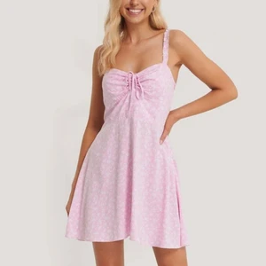 Söt Rosa Sommar Klänning - Pamela x NA-KD newborn, Pink flower. En skön och tunn söt rosa klänning med vita små blommor på från NA-KD, perfekt till sommaren. Helt nyskick. Passar mig som är XS. Nypris: 449. Frakt tillkommer