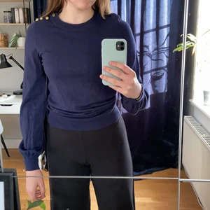 Finstrimlad tröja  - Finstickad tröja från Falsterbo X Gina tricot. Tröjan är marinblå vilket första bilden visar samt att den har guldiga knappar på vänstra axeln. Den har även lite av en ballongärm. Använd ett fåtal gånger.