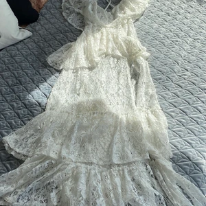 Klänning vit Storlek S - Somrig långklänning från Dennis Maglic, finns inget undertyg så är ganska genomskinlig. Hög slits på vänster sida som går upp till höften ungefär, dragkedja bak. Aldrig använd, nyskick! 