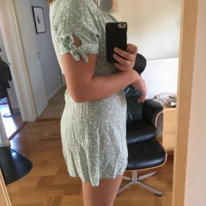 Klänning - En turkos klänning med små vita blommor på, med knytningar på ärmarna och blixtlås i ryggen i storlek 42. Men liten i storleken och kort på mig (173 cm). Men en jättefin klänning till sommaren, skön och bra kvalité🌸