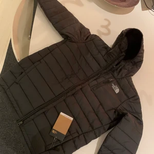 North face vadderad jacka  - Tunnare dunjacka från north face. Svart med go luva. Är junior storlek XL som är stor small, mot medium. Helt ny och oanvänd lapparna kvar!  