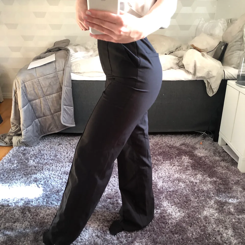 Svarta kostymbyxor med ett väldigt fint typ av pressveck fram på låren. Byxorna är i väldigt fint skick, säljer då de är för långa på mig som knappt är 160. Jeans & Byxor.