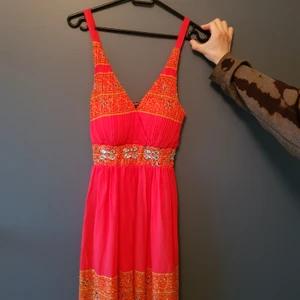 Färgglad klänning - Knälängd, med paljetter på. Det är XL men det är mest runt bröstet. Jag är S i det flesta och kan ha den på mig, så tänk på det