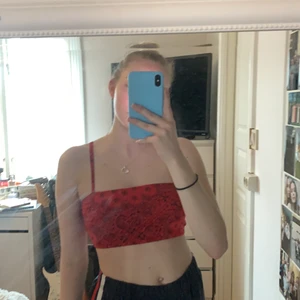 Kroppat rött linne med mönster, Storlek S. - Kroppat rött linne med svart mönster, lite bandana liknande mönster. Storlek S från forever 21, aldrig använd mer än prövad, säljer för att den är lite för liten för mig och inte riktigt min klädstil längre. Pris: 20kr + frakt 