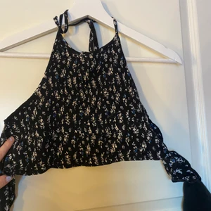 Topp från Nelly  - Storlek XS men passar S oxå. Snygg croppad topp med knyte baktill och runt nacken och öppen rygg. Snygg till festivaler men även om man går på stan