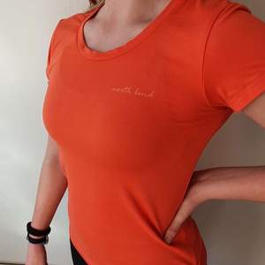 North Bend. Orange t-shirt för träning, mjukt material, väldigt skön att ha på sig. Snygg liten detalj på sidan. Frakten är inkluderad i priset som står 