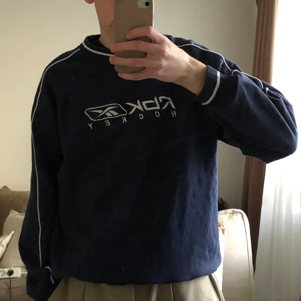 Reebok hockey sweatshirt i blå färg. Tröjan har vita streck runt halsen och armen. Storlek XS men är oversized.. Tröjor & Koftor.