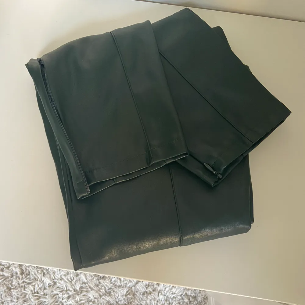 Jättefina mörkgröna byxor i skinn imitation från Mango i storlek XS, (jag är 167 cm). Snygg detalj med dragkedja längst ner. Mycket sköna och sparsamt använda! Köparen står för frakt . Jeans & Byxor.