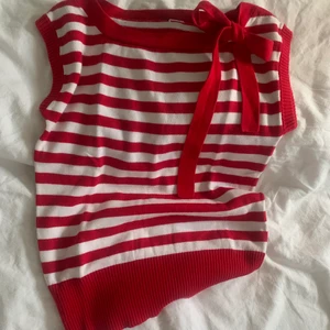 Söt stickad topp - Söt ribbstickad topp med ränder. Den är supersöt och har en röd rosett🤩