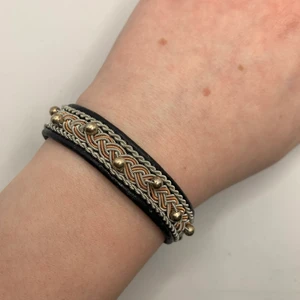 Tenntrådsarmband  - Handgjort Tenntrådsarmband, svart med kopparfärgad tenntråd och silverpärlor. Materialet armbandet är gjort i är lammskinn, och flätan är gjort i tenntråd. Armbandet kan hålla i flera år. Om du har någon fråga kan du gärna skriva en kommentar eller meddela mig.