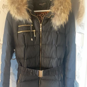 Hollies dam vinterjacka - Fin och varm vinterjacka som är i en lite längre modell med bälte samt en fin päls. Säljer den för att den har blivit för stor. Jackan är i storleken 42 men passar även 40-44. Jackan är i ett bra skick, använd cirka 10 gånger men köpte den för 1 år sedan. Hör av er för mer bilder. Köpt för 4500 kr men säljer den för 1200 kr men kan gå ner i pris för en snabb affär.