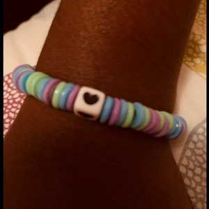Armband  - Den är ny och den har ett hjärta på sig och den är lila,blå,grön och rosa.