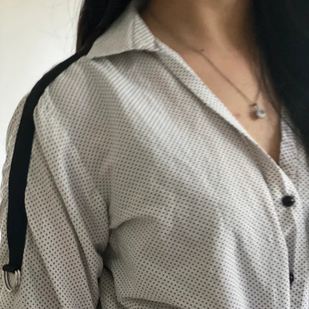 Svart och vit skjorta med svarta detaljer på axlarna. Använd fåtal gånger och i väldigt bra skick! (Notera att skjortan får att bära både uppknutet och ned). Blusar.