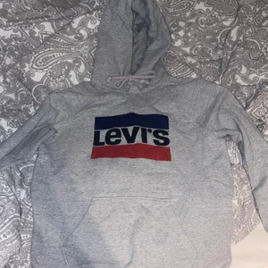 Grå Levis hoddie - Grå fin Levis Hoddie i st M, skicket är fint. Säljs då den blivit för liten för mig :) frakt står köparen för 
