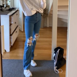 Raka jeans med hål från nakd  - Raka byxor från nakd. Byxorna är köpta i somras och har älskat dom sen dess. Dock har de blivit för små för mig så därför väljer jag att sälja. Hålen ser ut som på sista bilden. Köpta för 499 säljer för 200. Går att pruta. Frakten ingår ej. SPÅRBAR FRAKT. (Jag är 169cm)