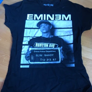 Eminem tröja - Eminem tröja köpt för 2 år sen som tyvärr inte kommer till användning. Har några defekter (se bild 2 och 3) som att texten är lite sprucken (men den faller ej av) och även en vit fläck. Storlek L men är lite mer som M. Nypris: 200kr. Pris: 90kr. Kan fraktas men du står för frakt!🥰