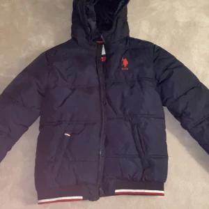  Marin blå USPA jacka från Polo  - Jag säljer min vinterjacka som jag bara använde en vinter som snabbt blev för liten för mig. Bra Skick och inge smuts 
