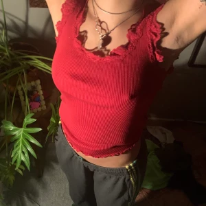 Rött ribbat linne med spetsdetaljer - Tight linne med mycket stretch! Sitter snyggt på kroppen⭐️ Jag brukar ha strl 34 för referens men skulle nog funka på XS-M pga stretch ‼️(Köp både röda och gröna linnet för 100kr)‼️