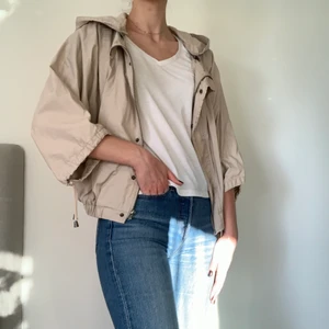 Jacka - Beige jacka med kortare ärmar från Zara i storlek M, köpt secondhand men aldrig använd av mig! Luvan går att ta av då den har en dragkedja. Har en svag fläck vid dragkedjan på framsidan vilket syns på andra bilden. 100% Bomull 🤍                               Kolla gärna in mina andra annonser!