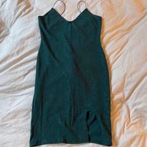 Grönklänning med glitter och en slits. Baktill är det ”räfflat” vid rumpan. Väldigt fin, bra kvalitet. Använd 1 gång. Storlek L men skulle säga M  Frakt tillkommer✨