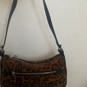 baguette väska - Leopard mönsterad baguetteväska med ett material liknande mocka. Ytterficka, och ficka på insidan finns. Perfekt storlek, rymmer mycket. Nypris 229kr