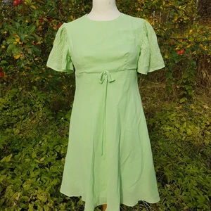 Vintage Retro Klänning, 60 tal 70 tal. - Super fin vintage klänning från 60 talet. Som direkt ur en 60 tals Elvis film! Den är i super fint vintage skick. På lappen står det strl 36, men utgå från måtten: Byst: ca 86 cm "Midja": 78 cm ( under brösten) längd på kjol: 61,5 cm.