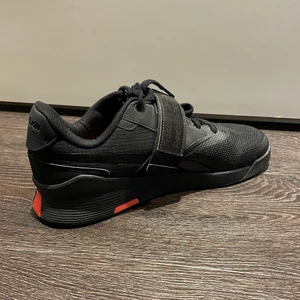 Reebok tyngdlyftarskor stl.44 - Ett par stabila träningsskor för tyngdlyftning från Reebok. Hälen är upphöjd ca. 2-3 cm, sulan är platt och mycket stabil. Skon har både snörning och kardborreband för extra stabilitet. Skorna är inköpta från Stadium för ca. 900kr i januari 2021 och är sedan dess endast använda upp till 5 gånger pga att jag slutat träna tyngdlyftning. Skorna är alltså i mycket bra skick och jag rekommenderar dem starkt vid tyngdlyftning. Storlek 44, skriv privat för info och bilder. Köparen står för frakt!