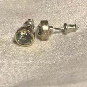 Silverpläterade örhängen från Pilgrim. Kristallerna mäter 0,6 cm i diameter. Ej använda.