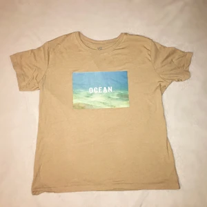 T-shirt ”ocean” - En sandfärgad t-shirt med tryck. Aldrig använd (förutom på bilden). Storlek L (unisex). Fraktalternativ väljer köparen. Meddela mig vid fler frågor!😊