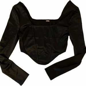 SVART KORSETT-TOPP - en svart korsett-liknande topp från h&m, helt ny, jättefina detaljer med boning ❤️ passar perfekt till typ allt! kan mötas upp i Uppsala och Stockholm, annars står köparen för frakten 🚚