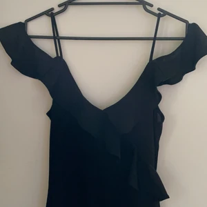 Body - Riktigt snygg body, aldrig använd. Jätte fina volanger som går snett över magen.