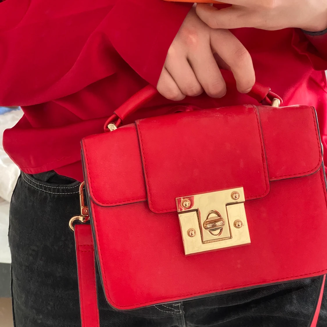 Röd väska med gulddetaljer