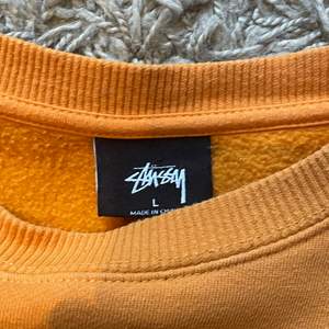 Orange Stussy crewneck i storlek Large