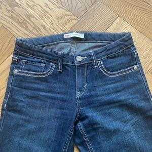 Levis 715 bootcut - Ett par jättefina lågmidjade bootcut jeans från Levis barnavdelningen i storlek 14 (år) som är knappt använda. Har måtten 73 cm i inseam, 70 cm i midja och 92 cm på hela byxlängden. De har sjukt häftiga bakfickor.