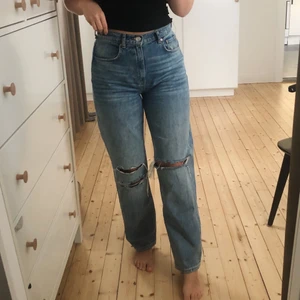 Blå jeans med hål - Blå jeans med hål strl 38 från Gina Tricot. 90s modell med snygga slitningar i knäna. Superfina och just den här färgen med hål är slutsålda. Säljer ett par till i samma modell i ljus färg med hål på knäna! Köp båda ihop för 400kr. Priset för dessa går att diskutera vid snabb affär.