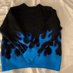 Svart ”stickad” tröja med blåa eldsflammor längst ner och vid armarna . Använd ett par gånger men kvalitet är fin ⚡️⚡️ storlek M men passar S och eventuellt mindre 💖
